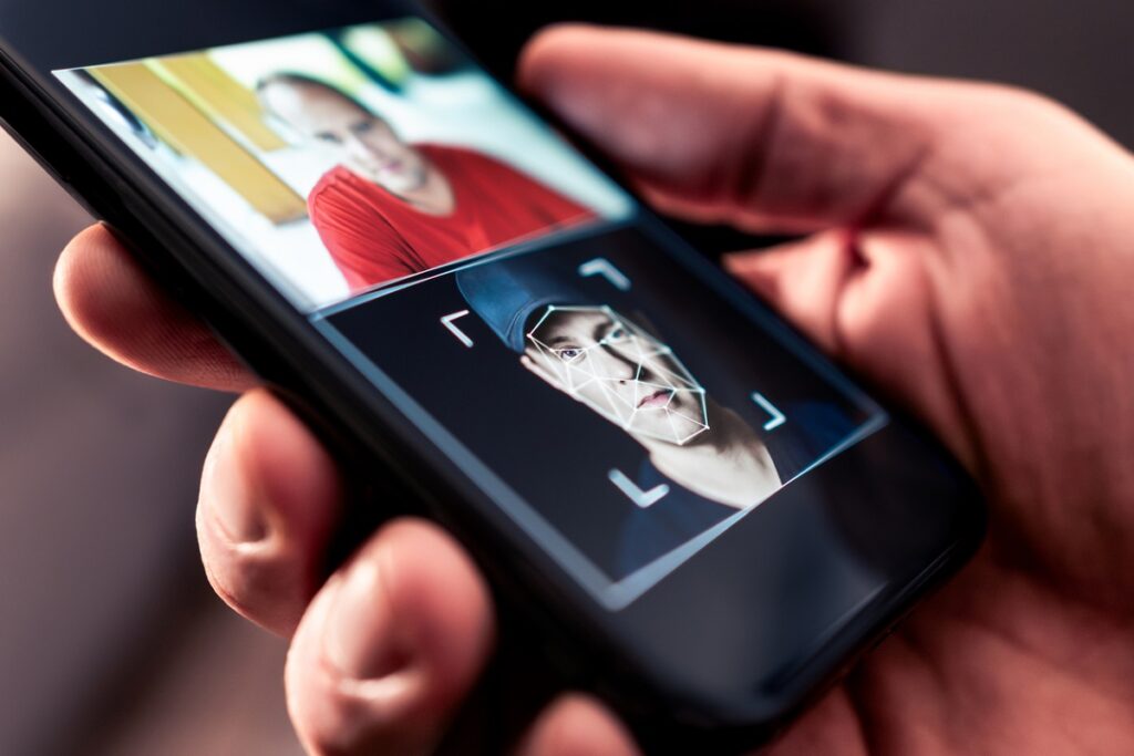 A closeup photo of a handheld smartphone showing a deepfake AI photo or video