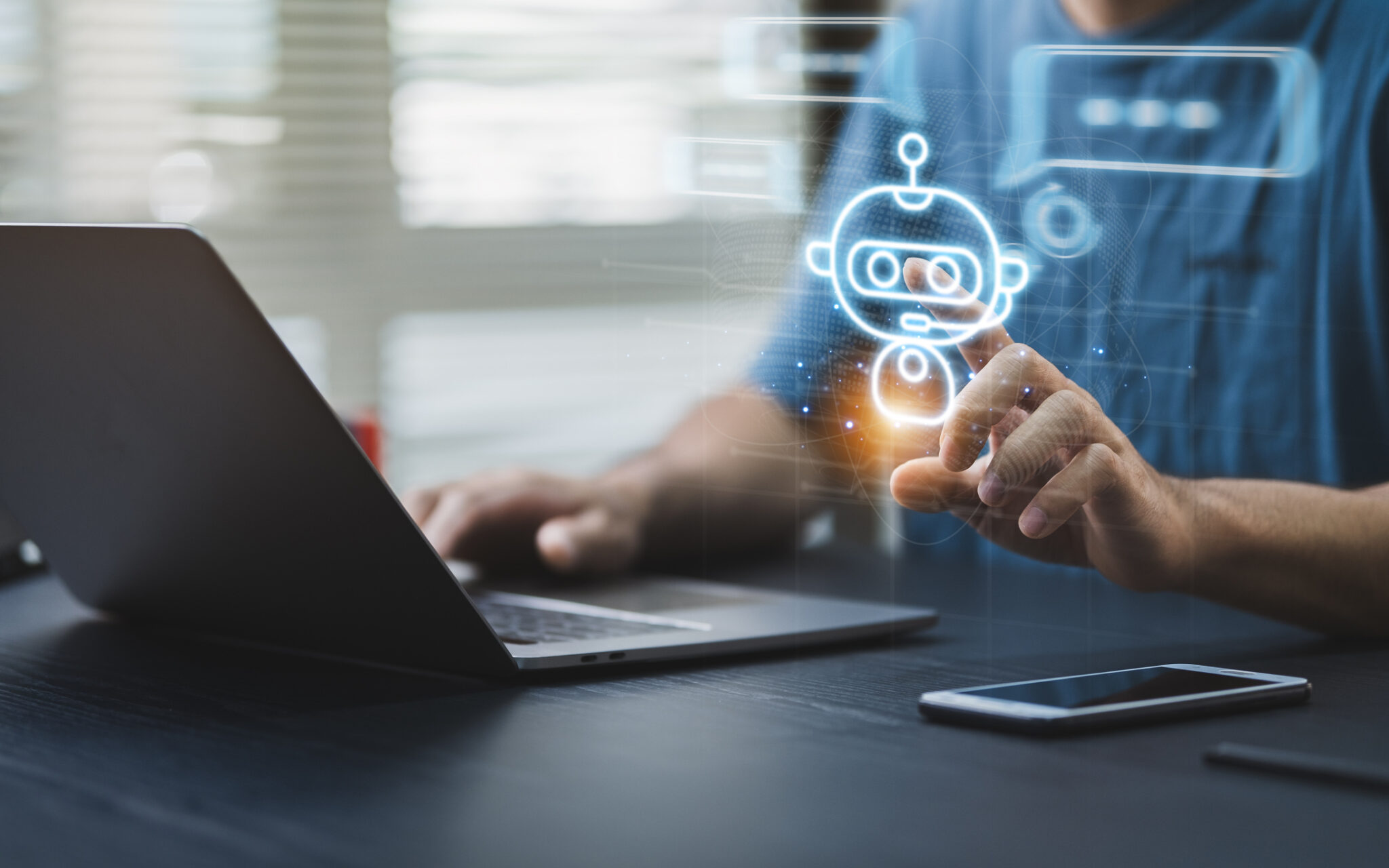 A man sitting at a laptop with an AI agent illustration floating above his hand