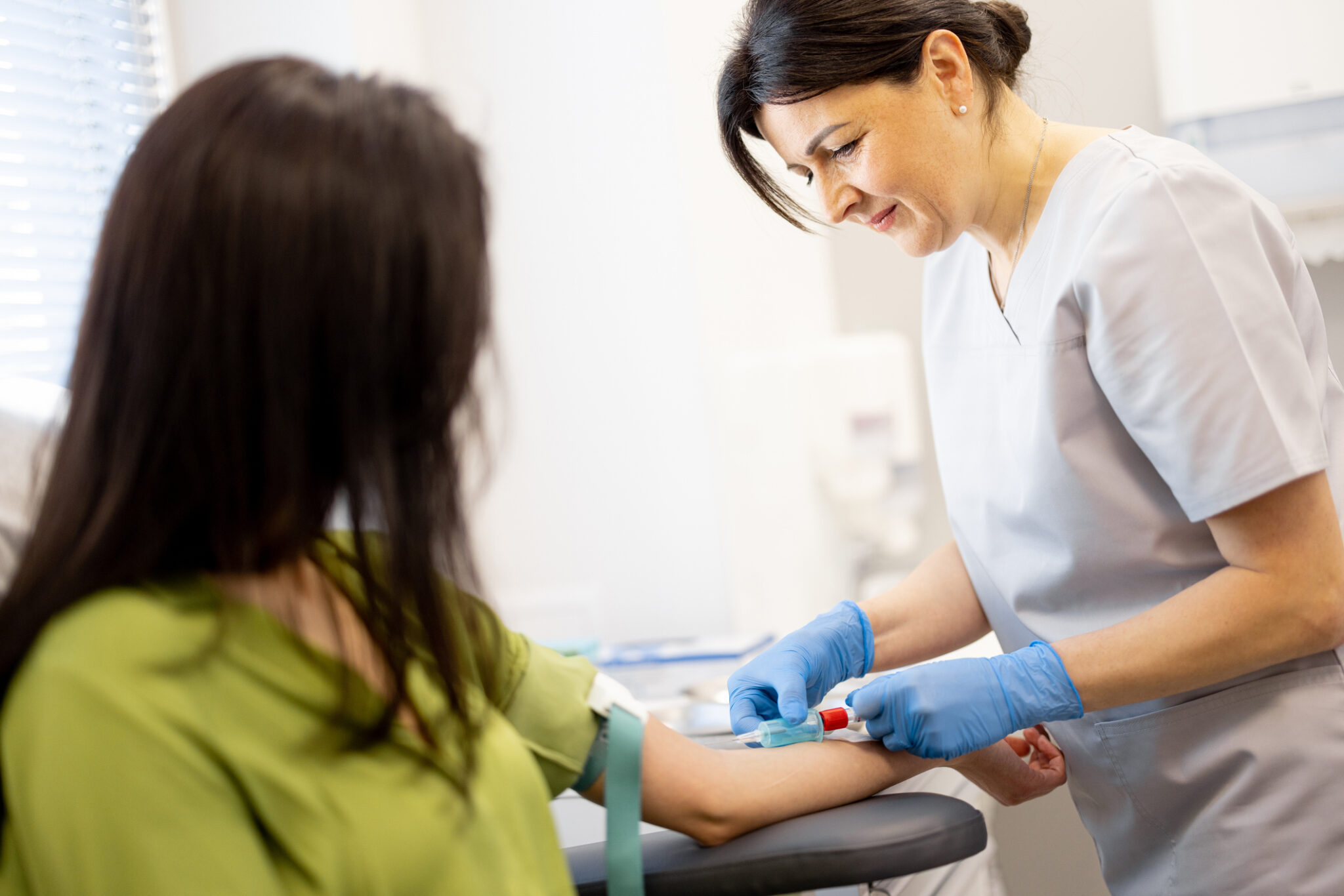 a nurse drawing blood from a patient